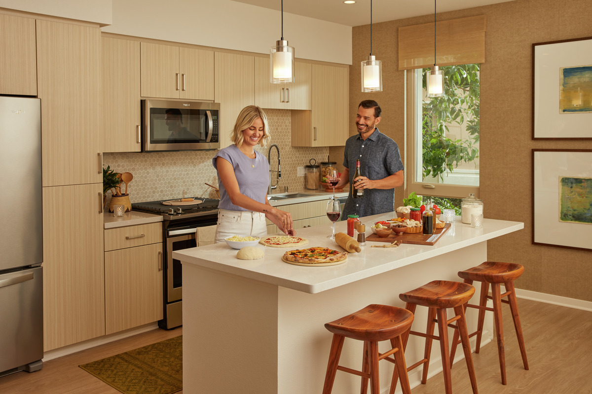 Couple in apartment home making pizza and preparing wine